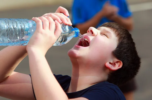 Bir çocuk hevesle içme suyu plastik şişe susuz — Stok fotoğraf