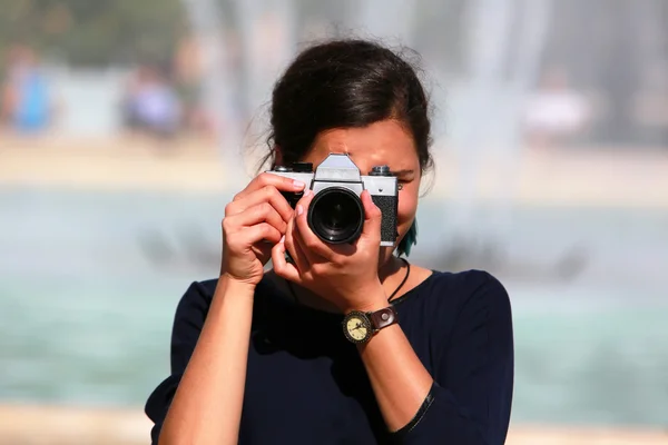 Mujer joven tomando una foto con una vieja cámara — Foto de Stock