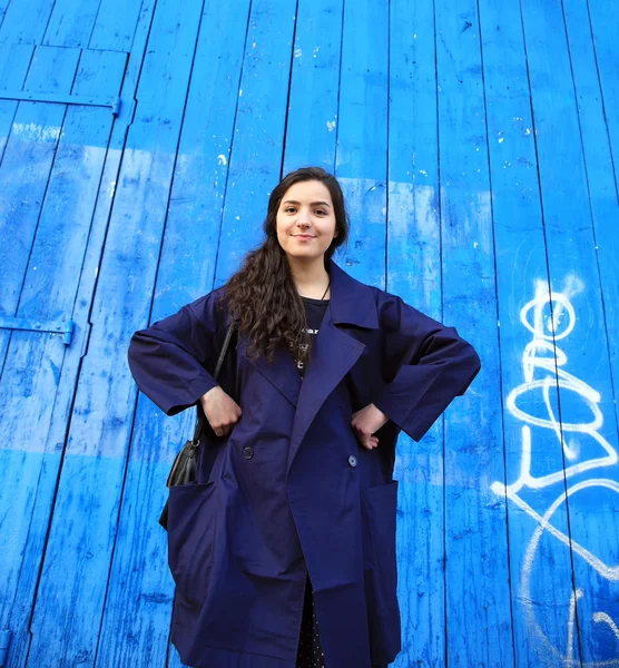 Hermosa mujer joven en el fondo de la pared azul — Foto de Stock