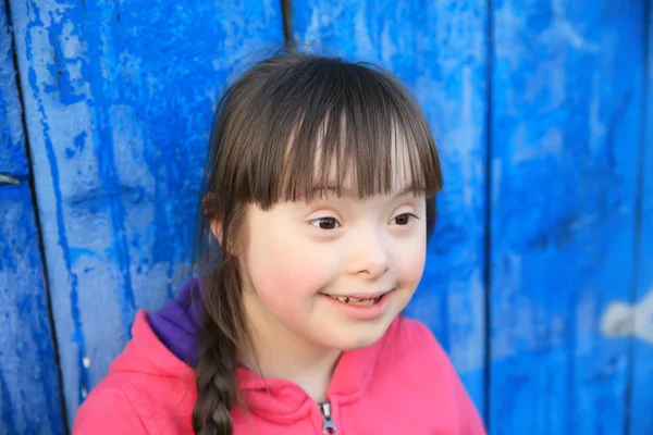 Menina sorrindo no fundo da parede azul — Fotografia de Stock