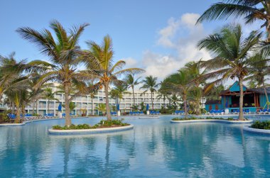 Large caribbean swimmming pool with hotel in background clipart