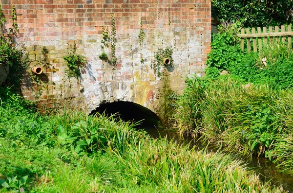 Ponte de tijolo vermelho sobre pequeno fluxo — Fotografia de Stock