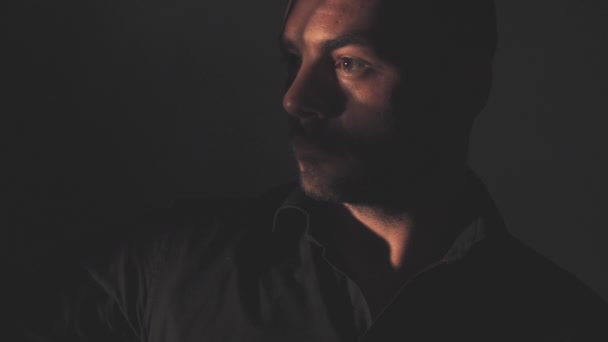 Retrato de un hombre con una camisa negra. Luz y sombra — Vídeo de stock