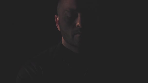 Портрет чоловіка в чорній сорочці. Світло і тінь — стокове відео
