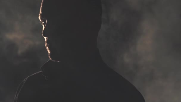 Egy fekete inges férfi portréja. Fény és árnyék — Stock videók