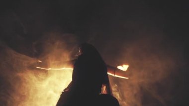 Woman dancing in smoke on a dark background