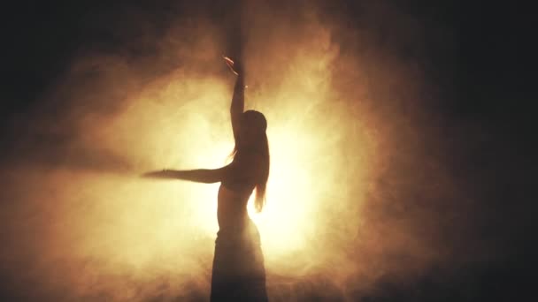 Woman dancing in smoke on a dark background — Video