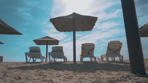 Playa de arena vacía. Playa con sombrillas y tumbonas — Vídeo de stock