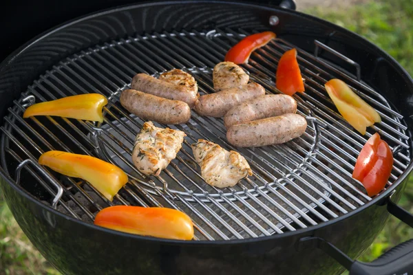 Saucisses, viande et légumes sur un gril — Photo