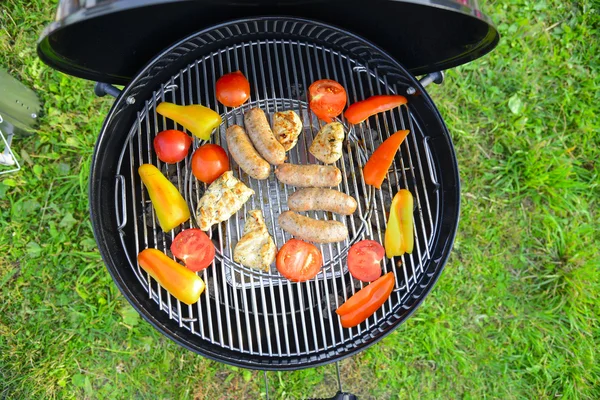 Saucisses, viande et légumes sur un gril — Photo