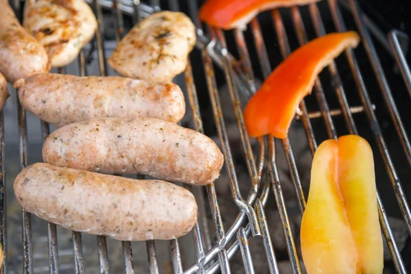 Saucisses, viande et légumes sur un gril — Photo