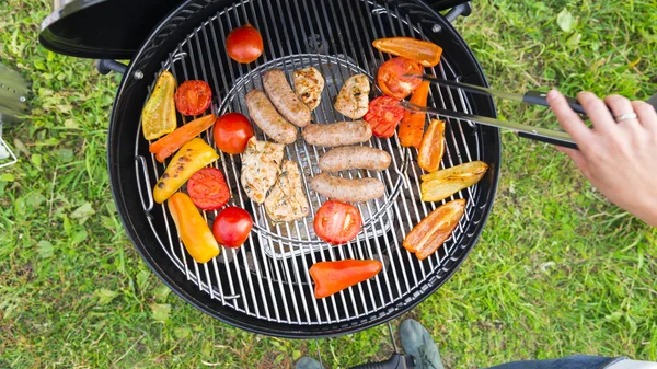 Saucisses, viande et légumes sur un gril — Photo