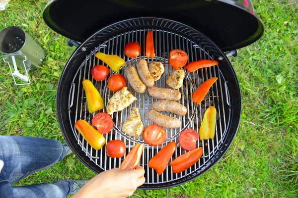 Saucisses, viande et légumes sur un gril — Photo