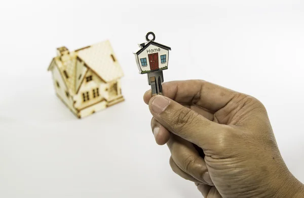 Huis knop ingedrukt met klein houten huis — Stockfoto