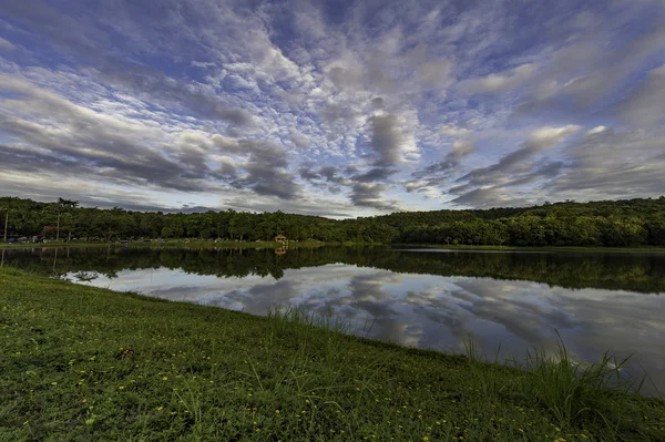 Cloudy sky over small lake in the forest — Stock Photo, Image