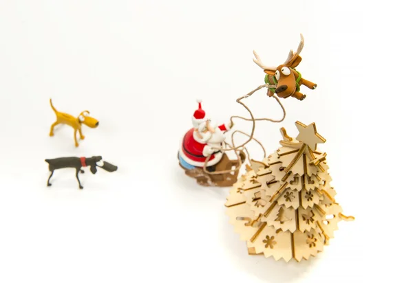 Rensdyr trække op Santa kane ind i himlen nær juletræ - Stock-foto