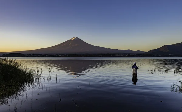 Un hombre pescando en el lago Kawaguchi con fondo de montaña Fuji — Foto de Stock