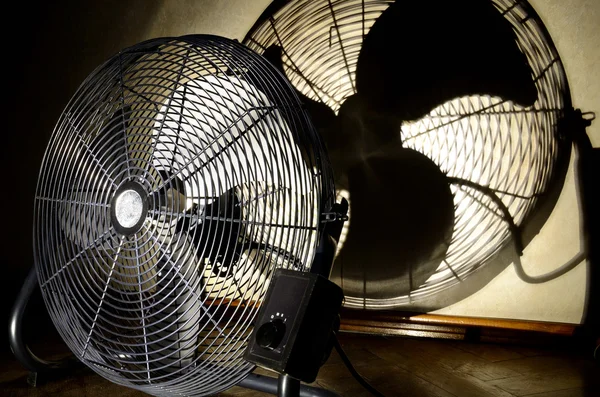 Ventilador elétrico e silhueta na parede Fotografia De Stock