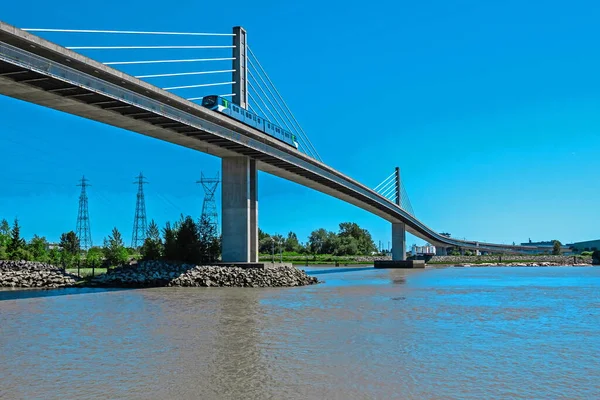 天空火车穿过弗雷泽河 通过连接里士满和温哥华市的天空 火车桥 对岸是高压电塔 背景是蓝天 — 图库照片