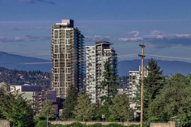 New Westminster 'da bir yerleşim yeri, bir dağ sırasının zeminine karşı özel evlerin bulunduğu muhitte birkaç tane yüksek katlı apartman.