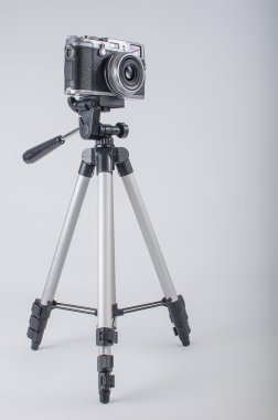 beyaz zemin üzerinde bir tripod üzerinde kamera olduğunu