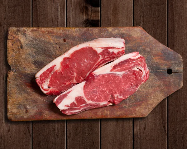 Carne crua na mesa de madeira . — Fotografia de Stock