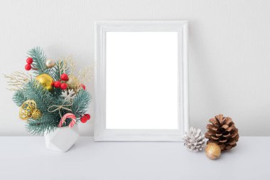 Noel posteri, yeni yıl buketi ve çam kozalaklarıyla süslenmiş. Kırmızı, altın ve beyaz süslemeler.