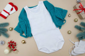 Bílé dětské tričko se svetrem na barevném pozadí s vánoční výzdobou. Rozvržení pro návrh a umístění log, reklama