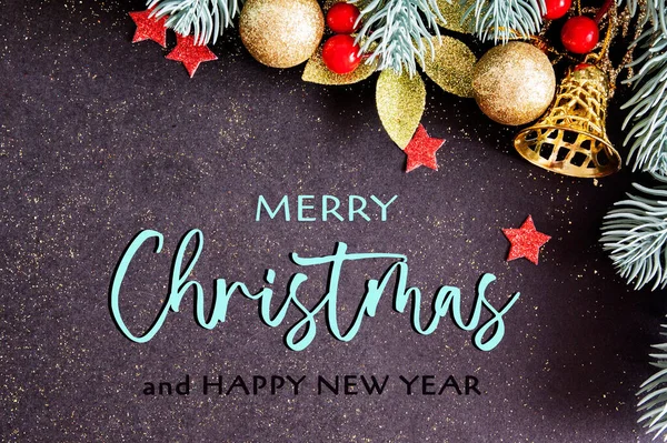 Tarjeta de Navidad con felicitaciones y ramas de pino con decoración sobre un fondo oscuro con purpurina —  Fotos de Stock