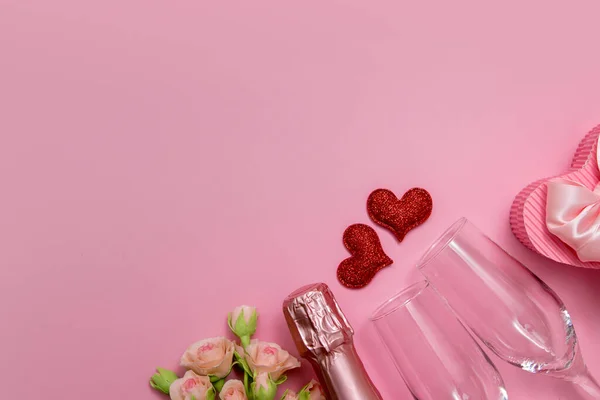 Legg ut to røde hjerter, briller, champagne, blomster på rosa bakgrunn med kopieringsrommets valentinsdag eller festkonsept – stockfoto
