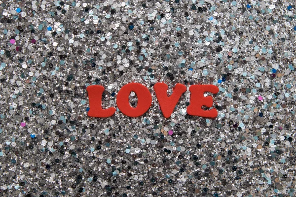 Η λέξη αγάπη με κόκκινα γράμματα σε ένα λαμπερό φόντο γκλίτερ για την Ημέρα του Αγίου Βαλεντίνου — Φωτογραφία Αρχείου