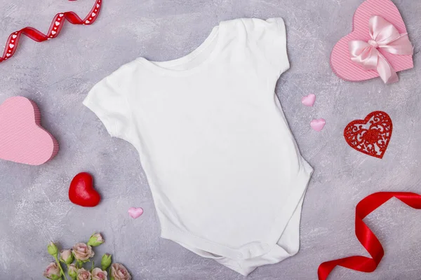 Ropa para niños maqueta de cama plana con decoración para el Día de San Valentín para logotipos y textos — Foto de Stock