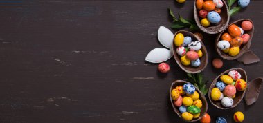 Tahta masa fotokopi alanında çikolatalı yumurta ve tavşanlı pankart. Mutlu Paskalya yumurtaları avlanma konsepti. Yukarıdan görüntüle