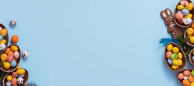 Paskalya bayrağı mavi arka planda renkli çikolata yumurtaları ve tavşancıklar bırakıyordu. Boşluğu kopyala
