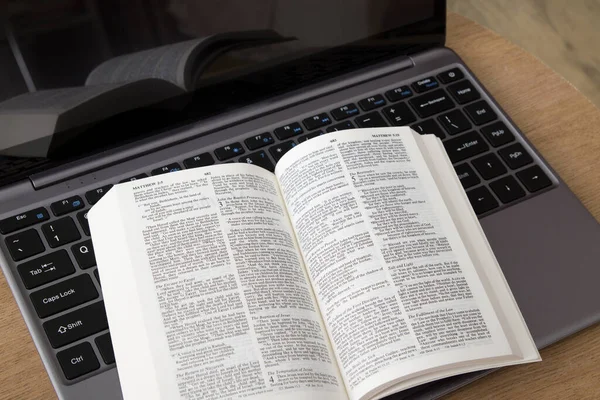 Vista superior de una biblia abierta en un portátil. Estudio bíblico, adoración en línea — Foto de Stock