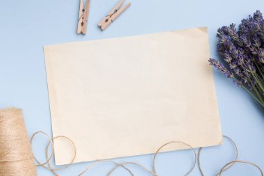 Boş bir kağıdın üst görüntüsü, lavanta ve mandallı sicim. Bahar ya da yaz konsepti
