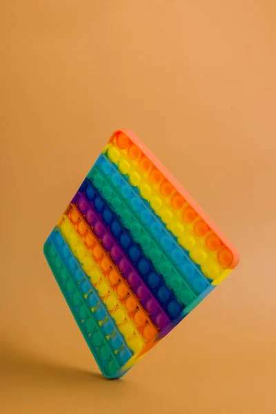 Floating arcobaleno giocattolo in silicone antistress pop su sfondo di colore. Giocattolo popolare per bambini — Foto Stock