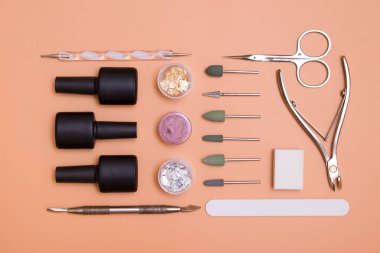 Modern jel manikür ve tırnak uzatmak için malzeme ve aletlerin üst görünümü. Renkli bir arkaplanda düğüm atmak. Düz yatar manikür araçları