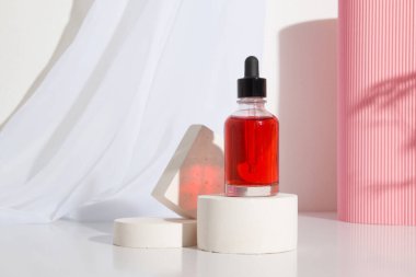 Kırmızı kozmetik sıvısı ya da podyumda yağlı pipetli cam damlası şişesi.