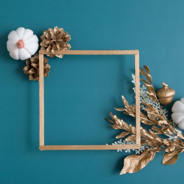 Turkuaz arka planda yazı için çerçevesi olan altın ve beyaz elementlerle dolu bir hayat. Minimalist sonbahar konsepti