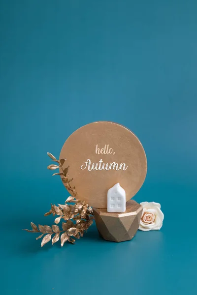 Hello Autumn inscription with still life of gold and white decorative elements and leaves on a turquoise background. Creative autumn concept — Fotografia de Stock