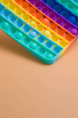 Yüzen gökkuşağı silikon elleri anti-stresi oyuncak gibi kullanıyor. Renk arkaplanına kopyalama alanı ile yapıştırıyor. Moda çocuk oyuncağı