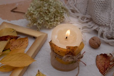 Düşen yapraklar, mumlar ve örülmüş bir battaniyeyle geçen bir sonbahar mahsulü. Sonbahar atmosferi kavramı