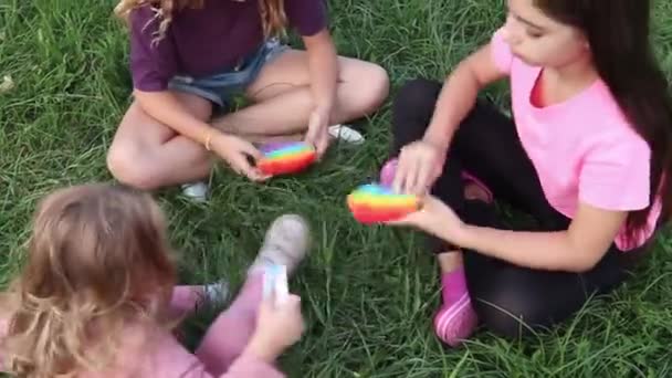 Girls Sit Grass Play Pop Sensory Silicone Toy Children Video — Stock Video