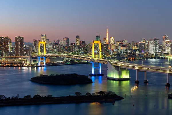 Panoramę Tokio o zmierzchu w Zatoce Tokijskiej, Rainbow Bridge i wieży Tokyo Tower są widoczne. — Zdjęcie stockowe