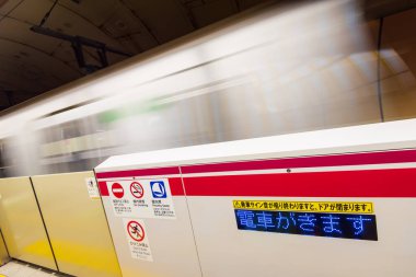 Tokyo, Japonya - 11 Aralık 2015: Tokyo, Japonya 'da bir metro istasyonunda geçen bir tren. 