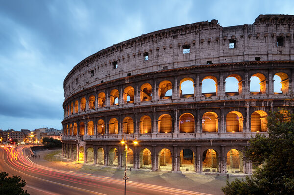 Colosseum at night with colorful blurred traffic lights.Rome - Italy