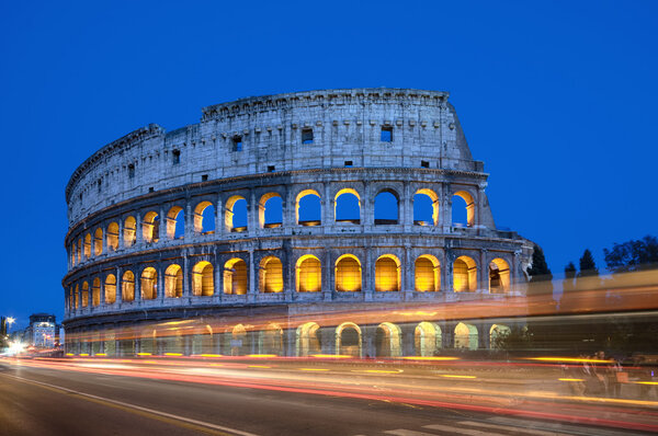 Colosseum at night with colorful blurred traffic lights.Rome - Italy