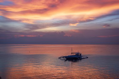 Günbatımı ile bir Banka tekne Bohol, Filipinler.