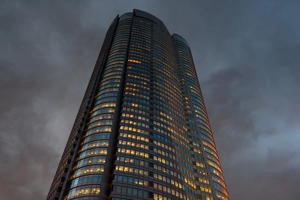 Kantoorgebouw 's nachts met een dramatische hemel. — Stockfoto